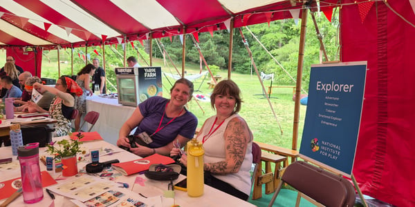 Palo Alto University faculty members sit under a circus tent smiling at the camera