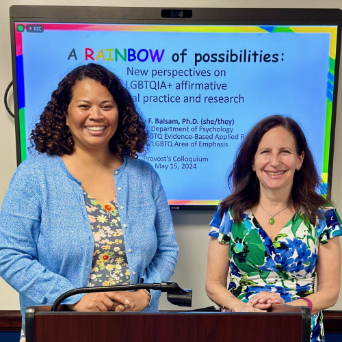 A photo of Provost Erika Cameron with Dr. Kimberly Balsam smile in front of a screen titled "A Rainbow of Possibilities." This photo was taken after Dr. Balsam's lecture as part of the Provost Colloquia series.